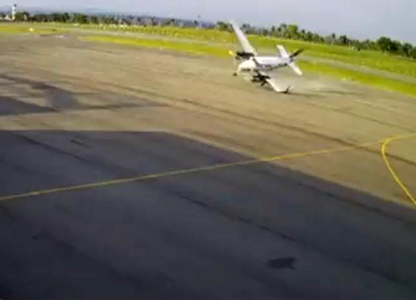 Fotograma de la cámara de seguridad del aeropuerto en el que se ve el Beechcraft King Air impactando primero contra la plataforma antes de deslizarse hacia el hangar.